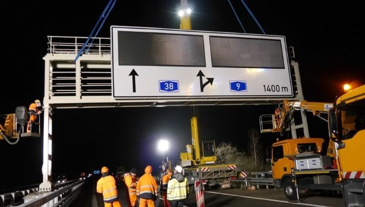 Nächtliche Montage einer Autobahn-Schilderbrücke