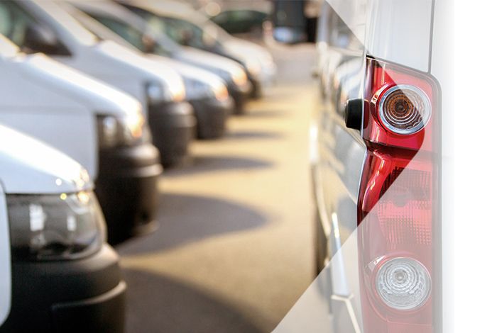 Viele weiße Lieferwagen stehen nebeneinander