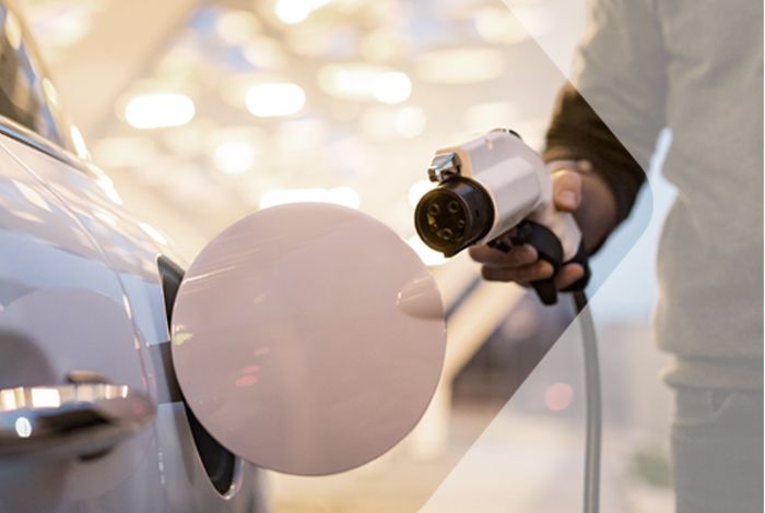 SWARCO MyCharge Pay Ein Mann hält einen Elektro-Lade-Stecker und wird gleich sein Elektro-Auto laden