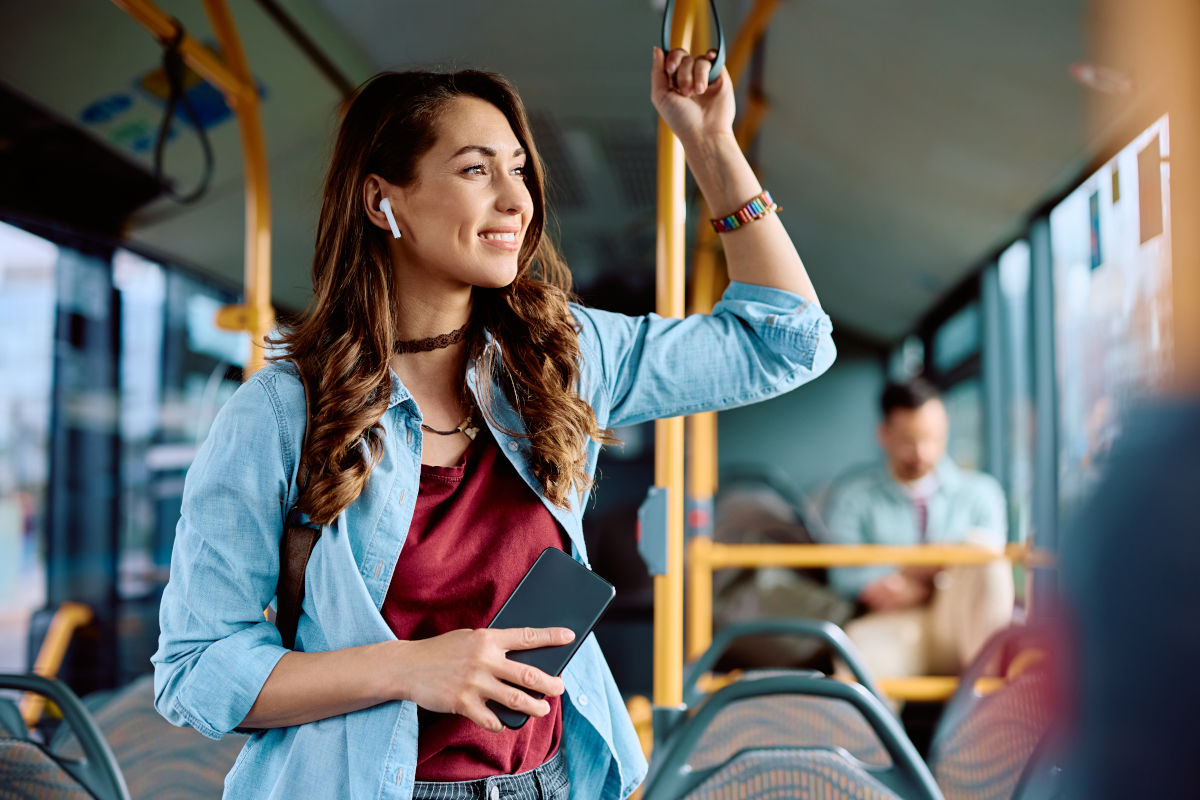 Mobilitätsmanagement: Kommunikation Frau mit Smartphone im öffentlichen Bus